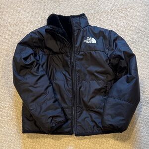 The North Face Kids Reversible Puffer Jacket in Black. Reverse side is faux fur